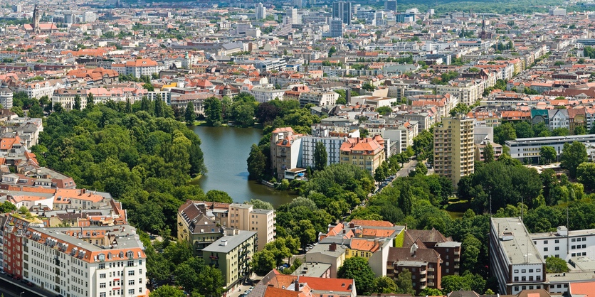 Aerial view across the tranquil oasis of the Lietzensee park and lake with its green parkland surrounded by the houses and streets, apartment blocks and office buildings of Charlottenburg, Berlin. ProPhoto RGB profile for maximum color fidelity and gamut.